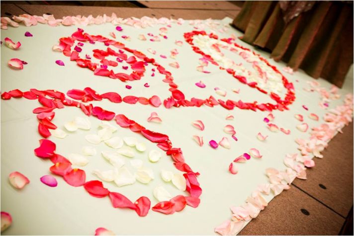 Wedding ceremony aisle covered in pink and red rose petals