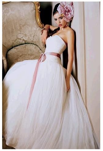 Vera Wang strapless wedding dress with dusty rose sash and oversized fascinator