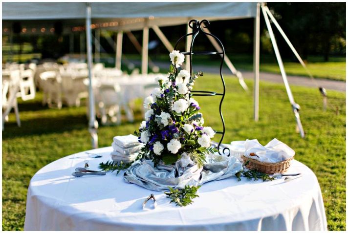 Gorgeous backyard wedding, with white tent and tables, white, purple and green floral centerpieces