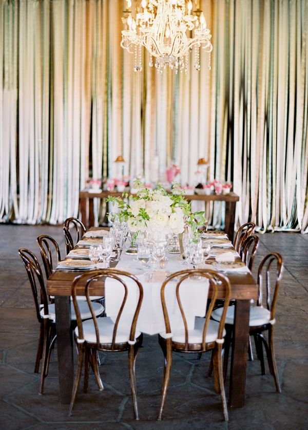 Beautiful wedding ceremony decor, with ribbon wall, chandelier and pink flowers