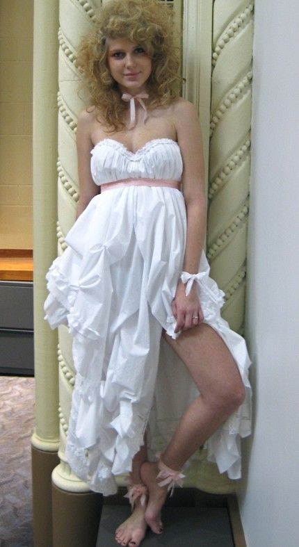 Tattered white wedding dress with sweetheart neckline and pink ribbon under bust
