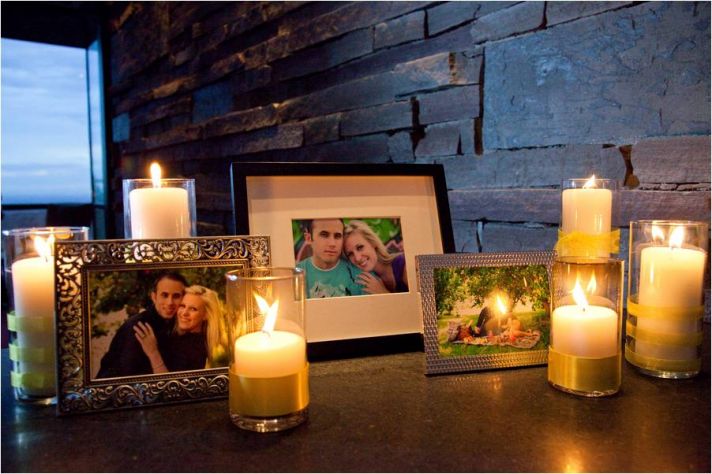 Escort table at wedding reception with framed photos of the couple, and romantic pillar candles
