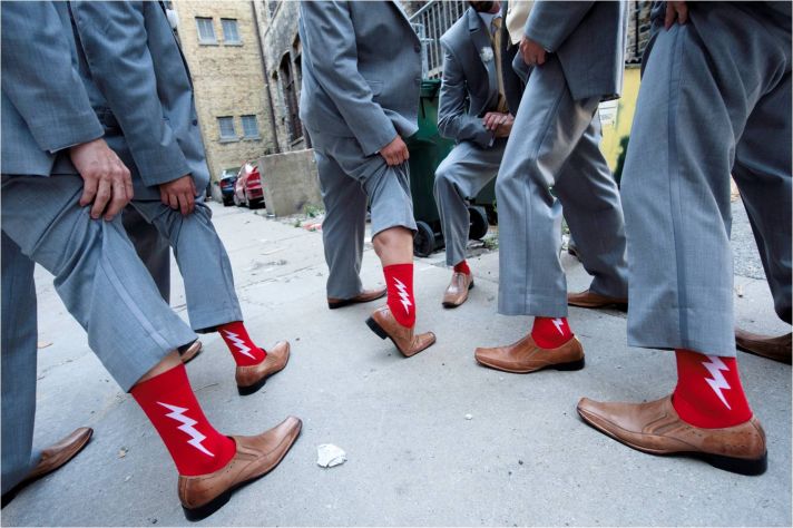 Groomsmen wear grey suits, show off funky red socks