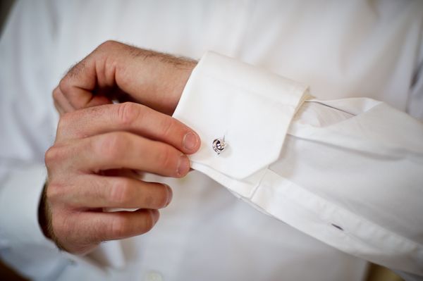 Groom puts on wedding cuff links