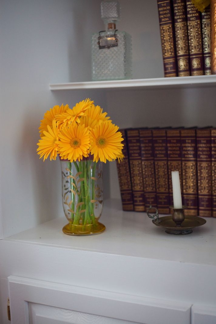 Elegant wedding venue with vintage bookshelf, yellow wedding flowers