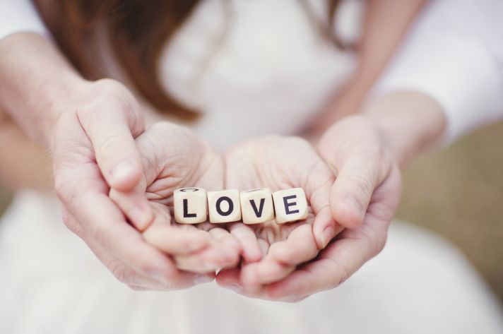Bride and Groom Hold Dice Spelling Love