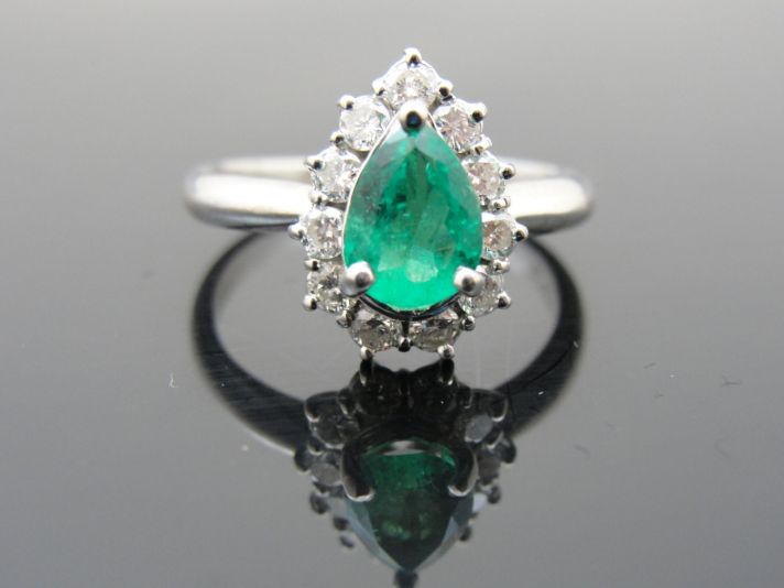 Emerald engagement ring with diamond halo