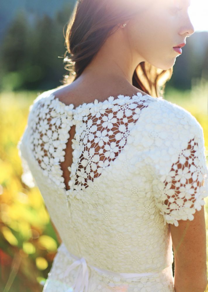 Romantic white crochet wedding dress with sheer sleeves and sash