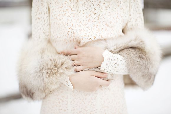 winter bride wears lace coat with fur stole