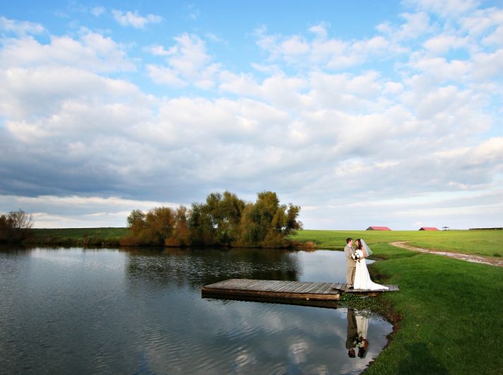 Gorgeous blue bird sky with fluffy clouds make the perfect backdrop for this bride and groom