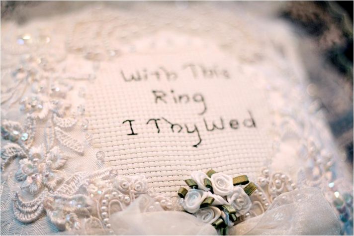 White handmade ring bearer pillow that reads With This Ring I Thy Wed