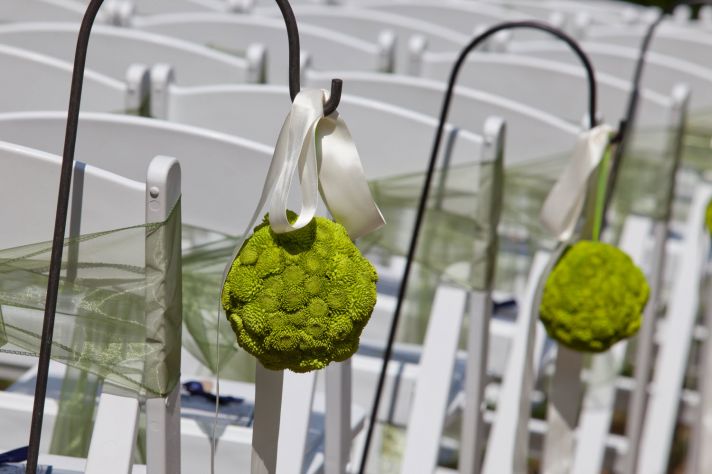 Elegant outdoor garden wedding reception with green wedding flowers and ivory satin ribbon decor