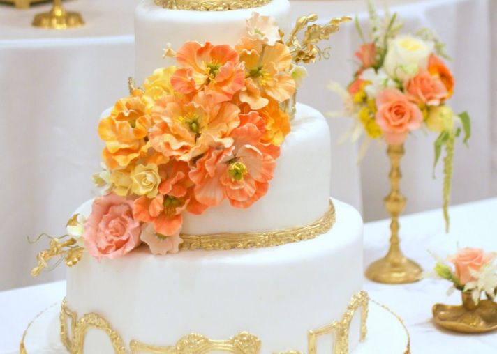 White and Gold Wedding Cake with Bright Peach Orange Yellow Sugar Flowers