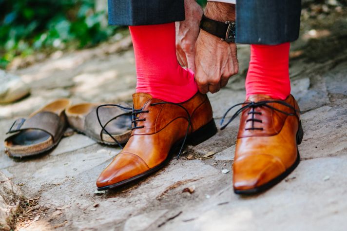 Grooms shoes with bright red socks