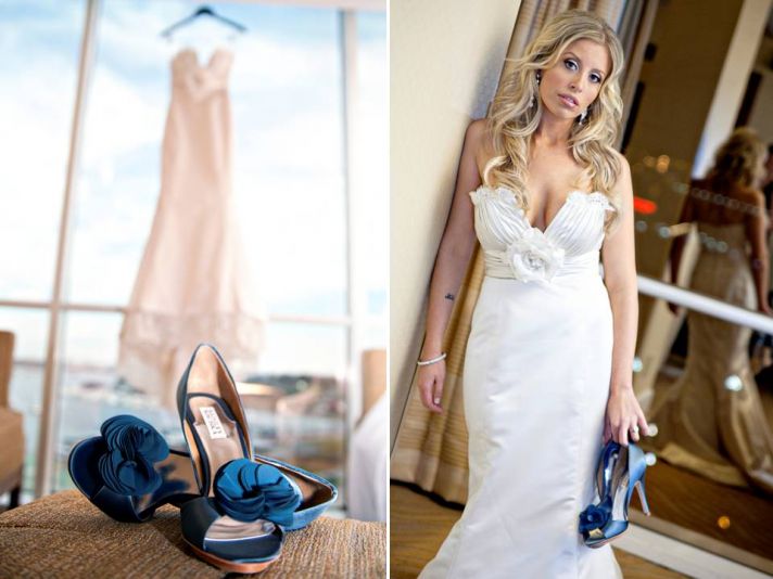 Ivory lace wedding dress hangs in window of wedding venue, bride holds blue peep-toe wedding heels