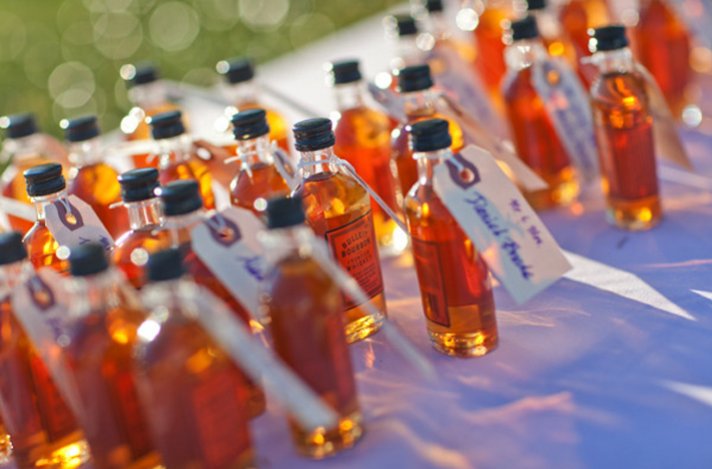 wedding reception escort cards attached to mini booze bottles