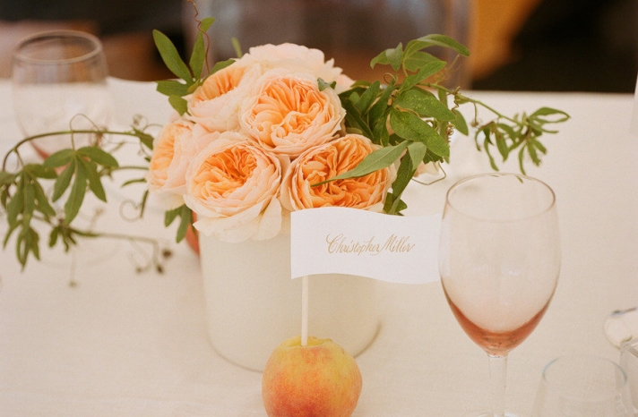 fruit incorporated into wedding reception centerpieces peaches hold escort cards