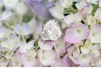 Light lilac and hydrangea cream wedding flowers with engagement ring