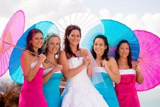 Fun, flirty colorful blue and pink parasols held by bridesmaids