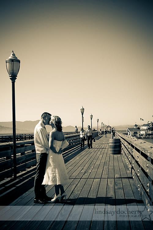Stunning vintage-inspired wedding photo of bride and groom kissing on pier