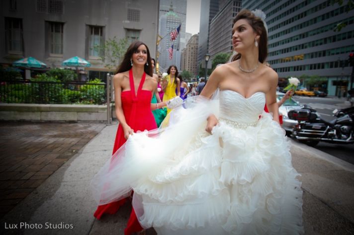 A strapless white dress is always appropriate on a bride. This bride’s low cut bodice and full skirt