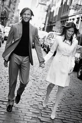 Beautiful European bride and groom walk hand in hand, bride in knee-length coat dress