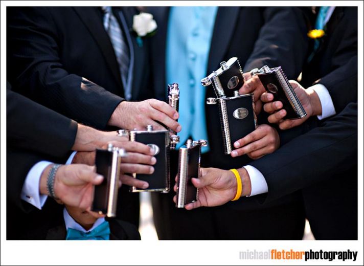 Groom and groomsmen cheers and toast the happy couple at the wedding