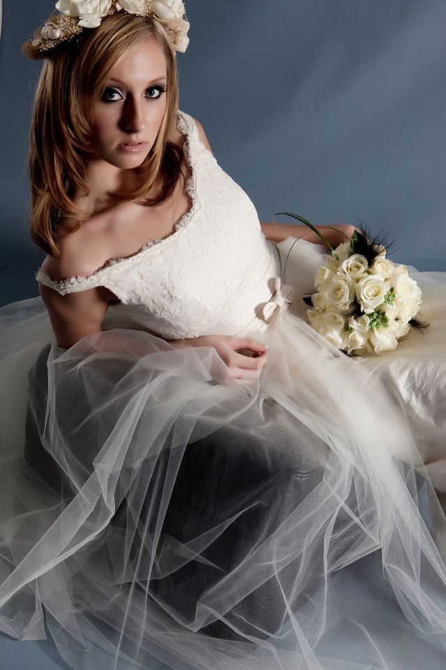 Off-the-shoulder ivory lace wedding dress with floral bridal headpiece