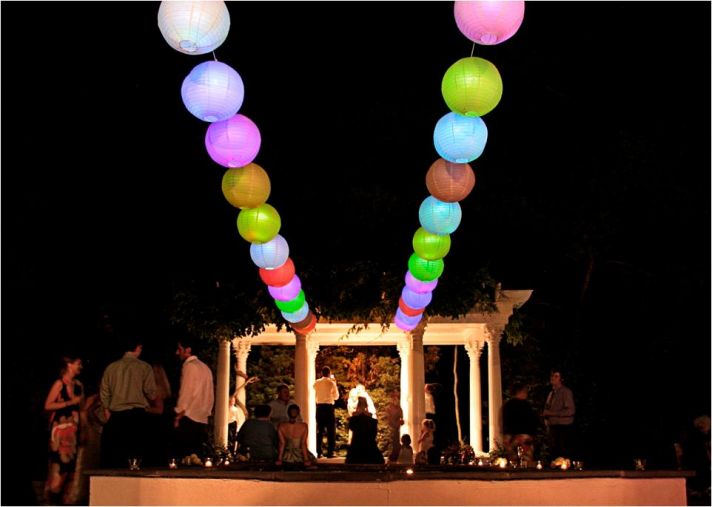 Romantic night outside at wedding ceremony venue- colored lanterns light up the sky
