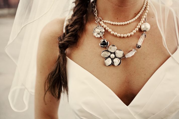 Bohemian bride wears v-neck wedding dress, statement bridal necklace