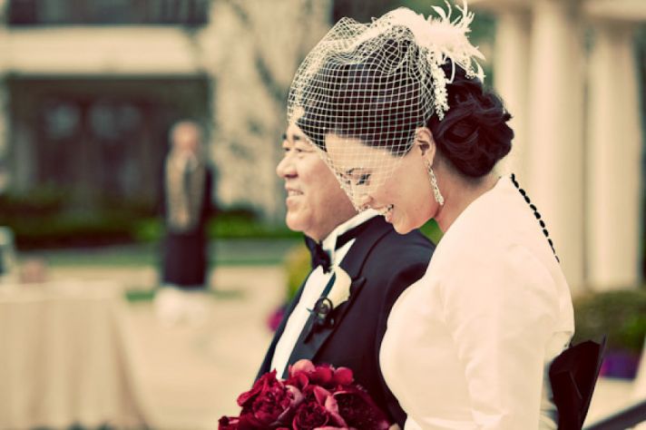 vintage glam bride wears birdcage veil and dress with covered buttons