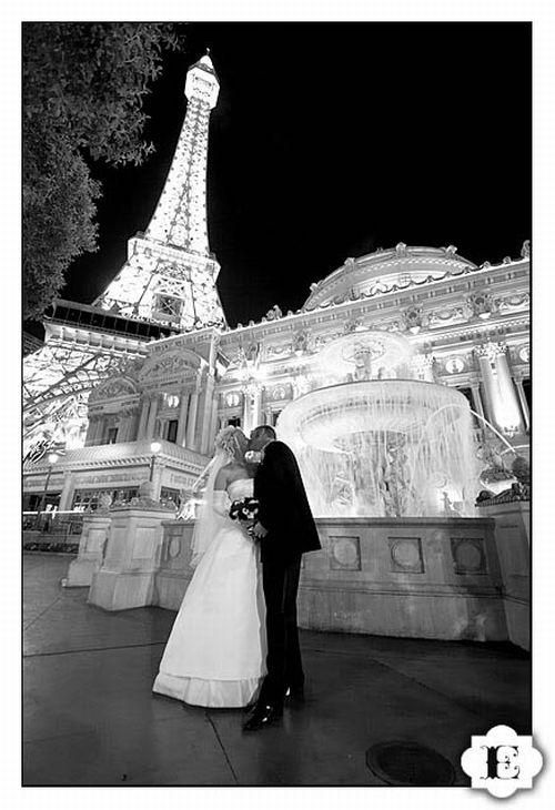 Black and white wedding photo- Bride and groom kiss with Eiffel Tower in background