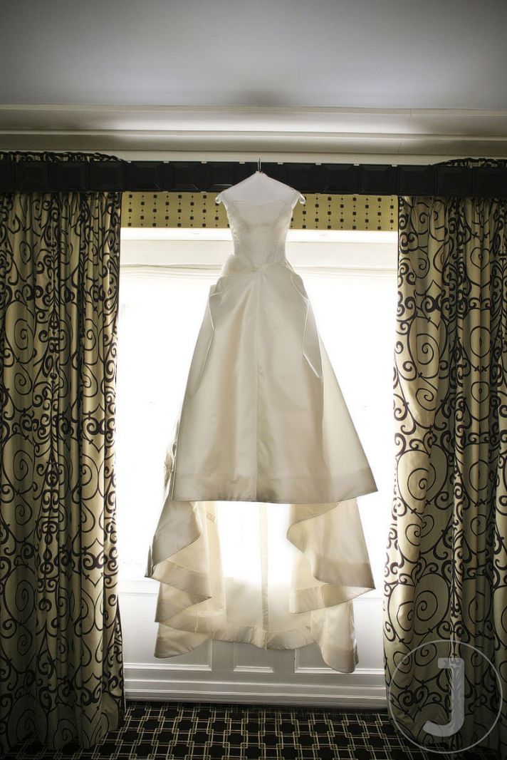 The bride’s beautiful Vera Wang ivory wedding dress hangs in the window of her New York City hotel r