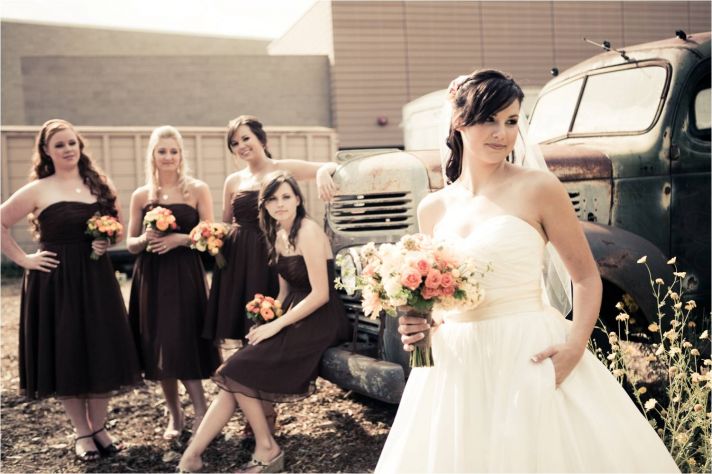 Bride in classic ball gown wedding dress poses with bridesmaids, wearing chocolate brown strapless d