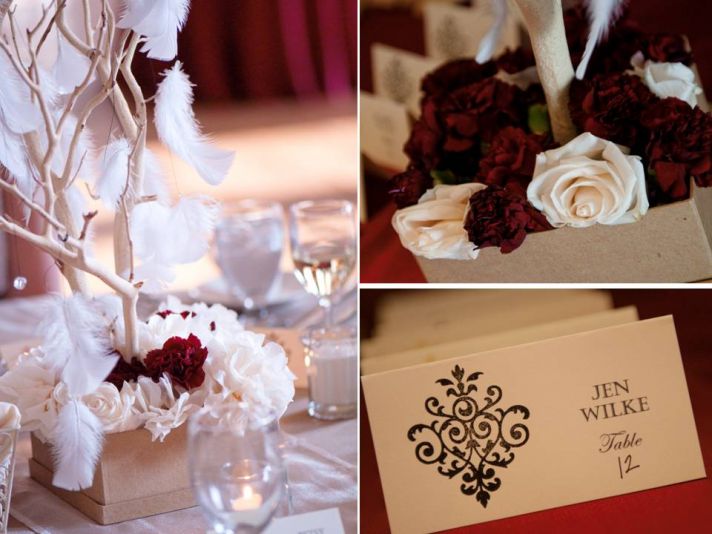 Deep red and ivory wedding reception decor with roses, manzanita branches and feathers