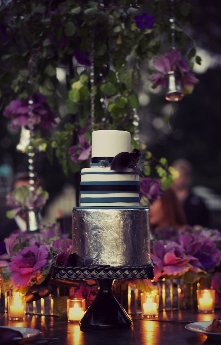 Cake table with purple flowers and votives