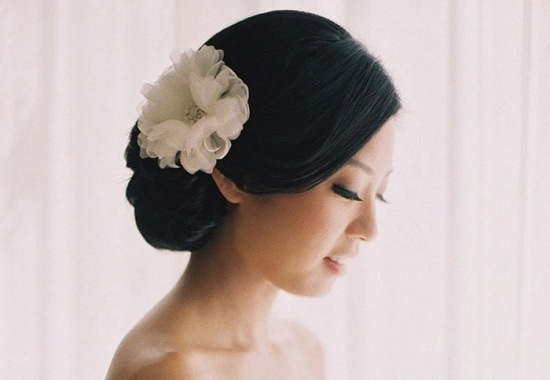 Classic chignon wedding hair with white flower