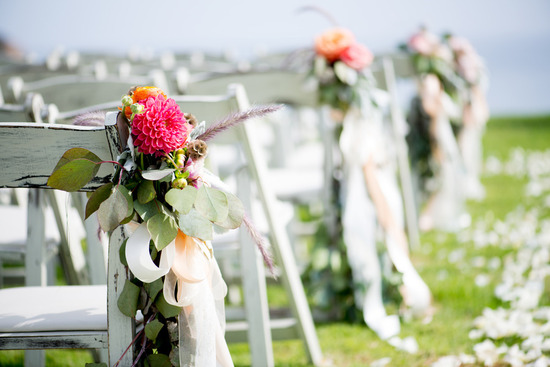 Hot-pink-dahlias-and-peach-ribbons-adorn-ceremony-chairs.medium_large