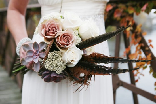 Gorgeous wedding bouquet with roses succulents and feathers
