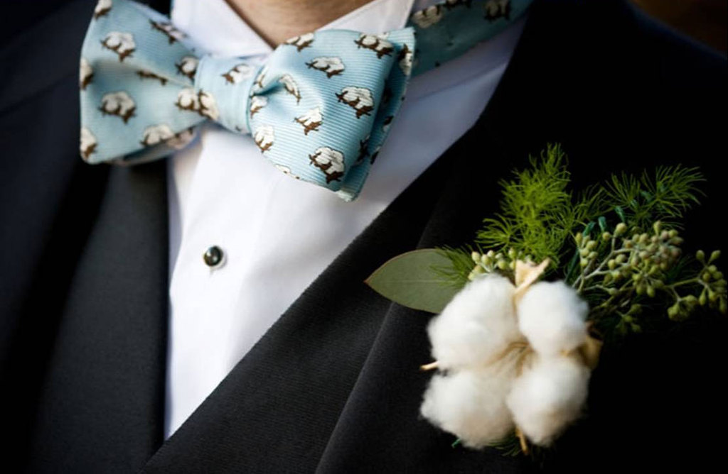 Groom-wears-cotton-boutonniere-with-patterned-bow-tie.full