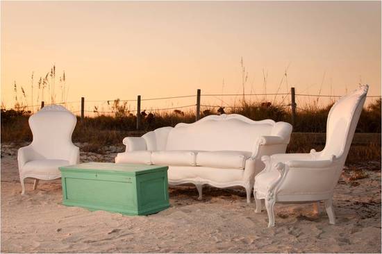 Vintage white lounge pieces for outdoor wedding reception on the beach