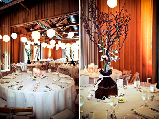Rustic wedding reception venue with high floral centerpieces featuring manzanilla branches