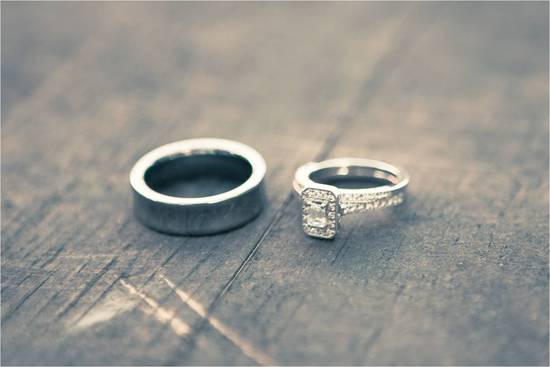Pave diamond engagement ring sits with groom's wedding band