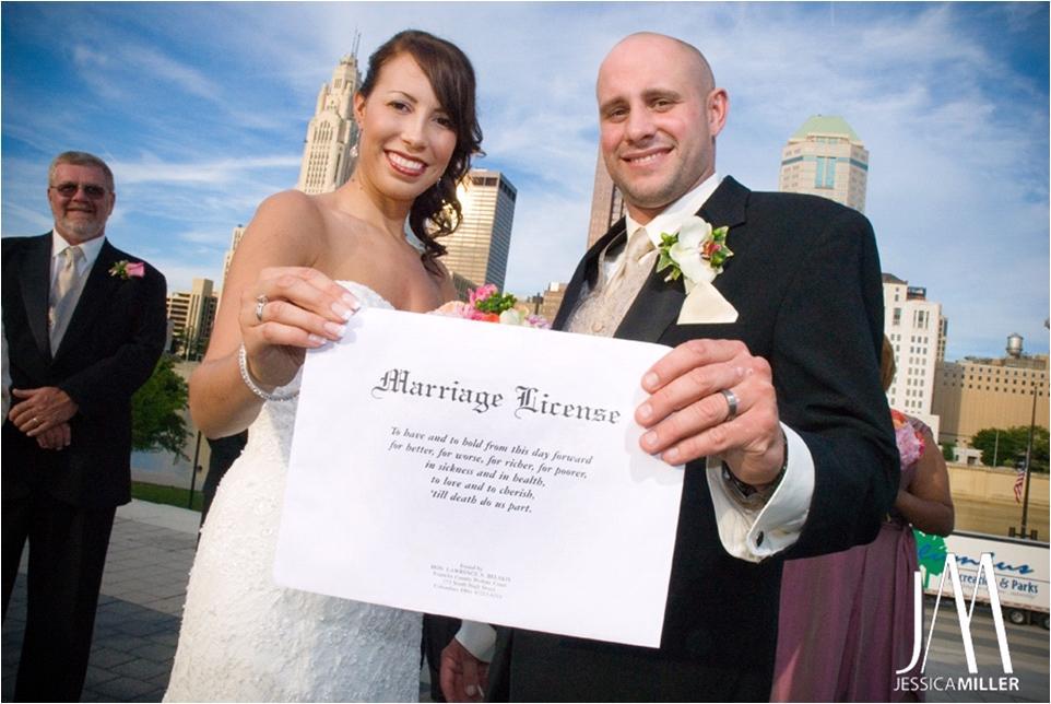 Bride-white-strapless-wedding-dress-groom-black-tux-proudly-show-off-marriage-liscense.full