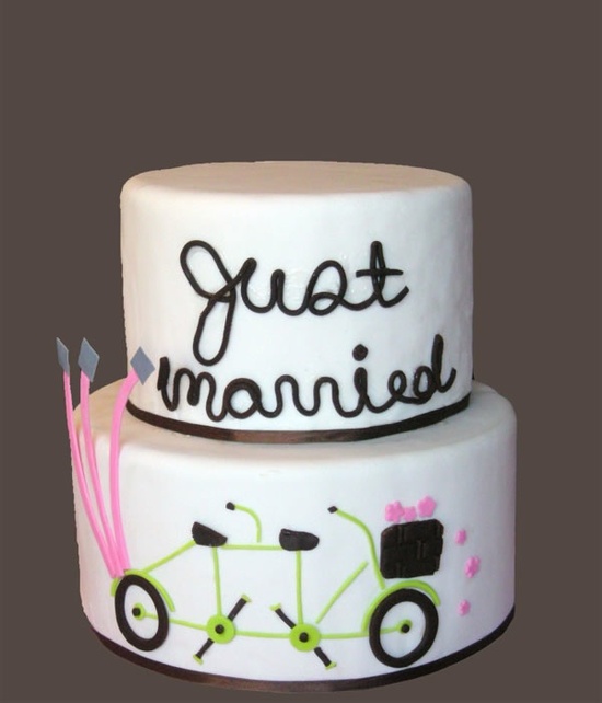 This two tiered white wedding cake is whimsically decorated.
