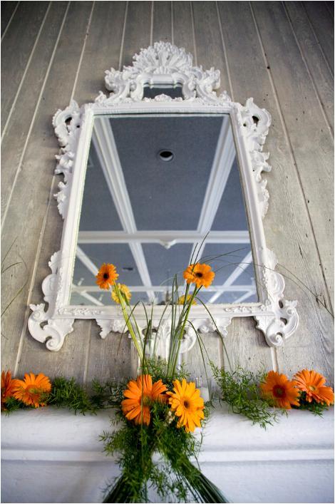 Jagger-wedding-detail-shot-antique-vintage-feel-mirror-with-white-frame-orange-flowers.full
