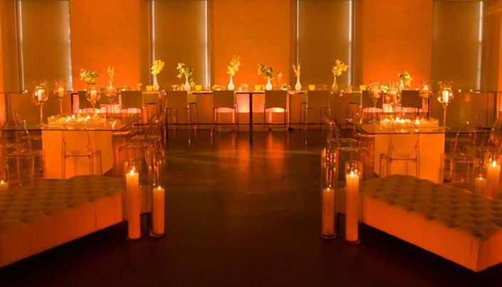 Beautiful orange, amber and yellow wedding reception room with clear tables and chairs