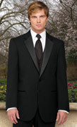 photo of This handsome blond groom wears a black two-button tuxedo with silk lapels and a black silk tie and 