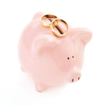 This pink piggy bank with gold wedding rings helps remind us that weddings and money are related.