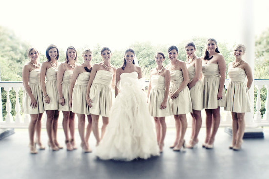 photo of bride poses with bridesmaids in short gold dresses